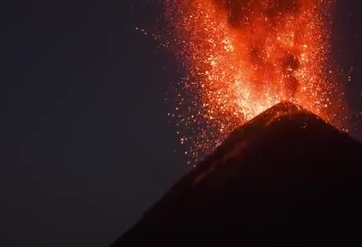 Lava bursting from a volcano summit.