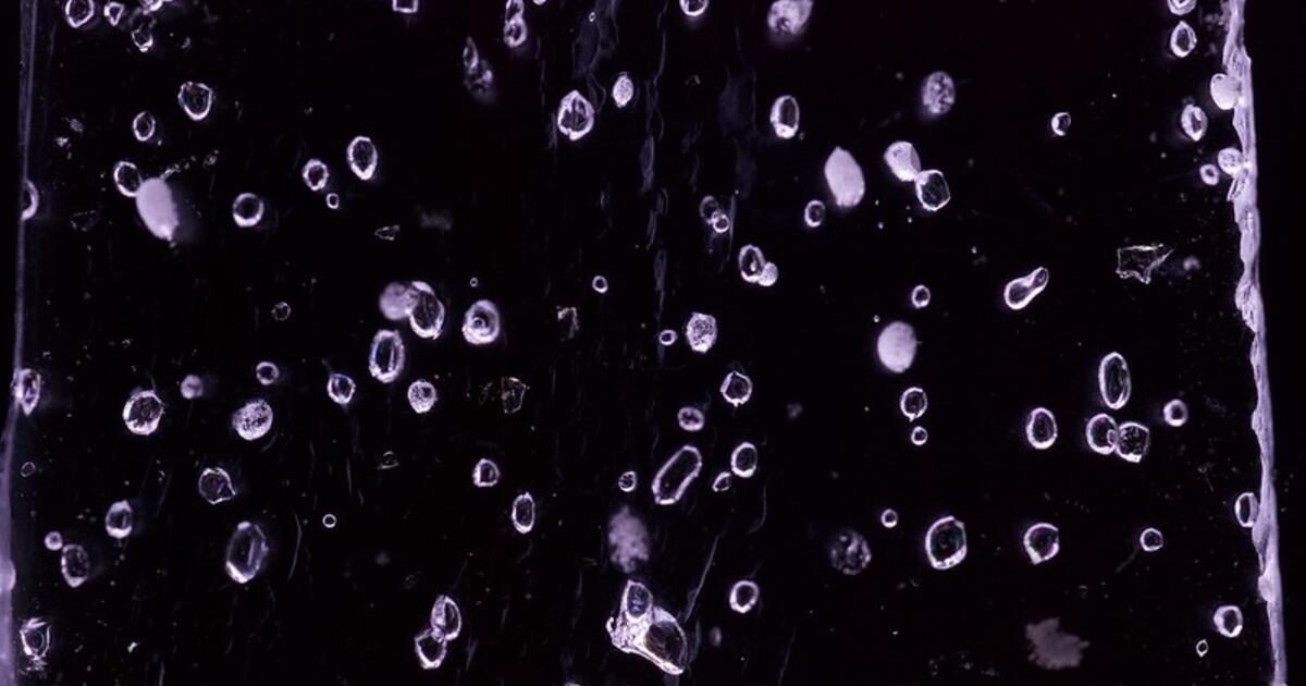 Close-up of ancient Antarctic ice with trapped air bubbles lit from behind