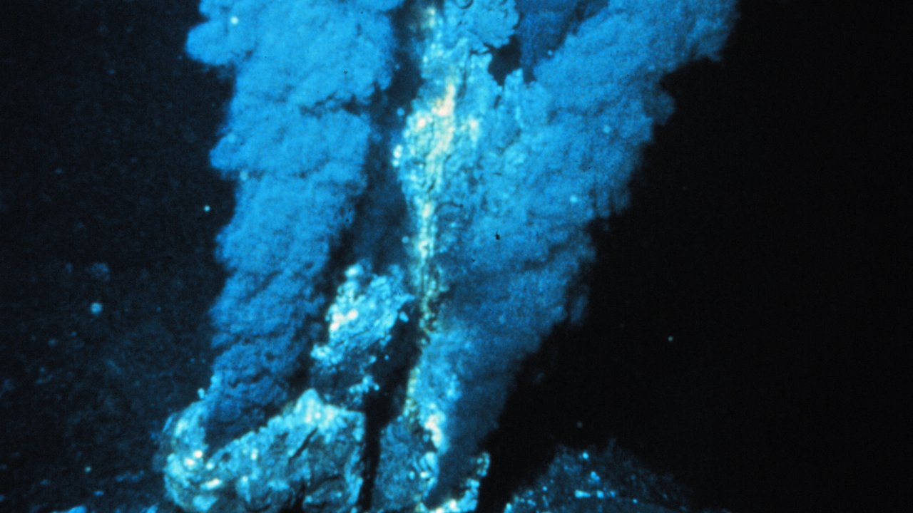 A black smoker hydrothermal vent on the Atlantic sea floor pouring out clouds of dark, mineral-rich water.