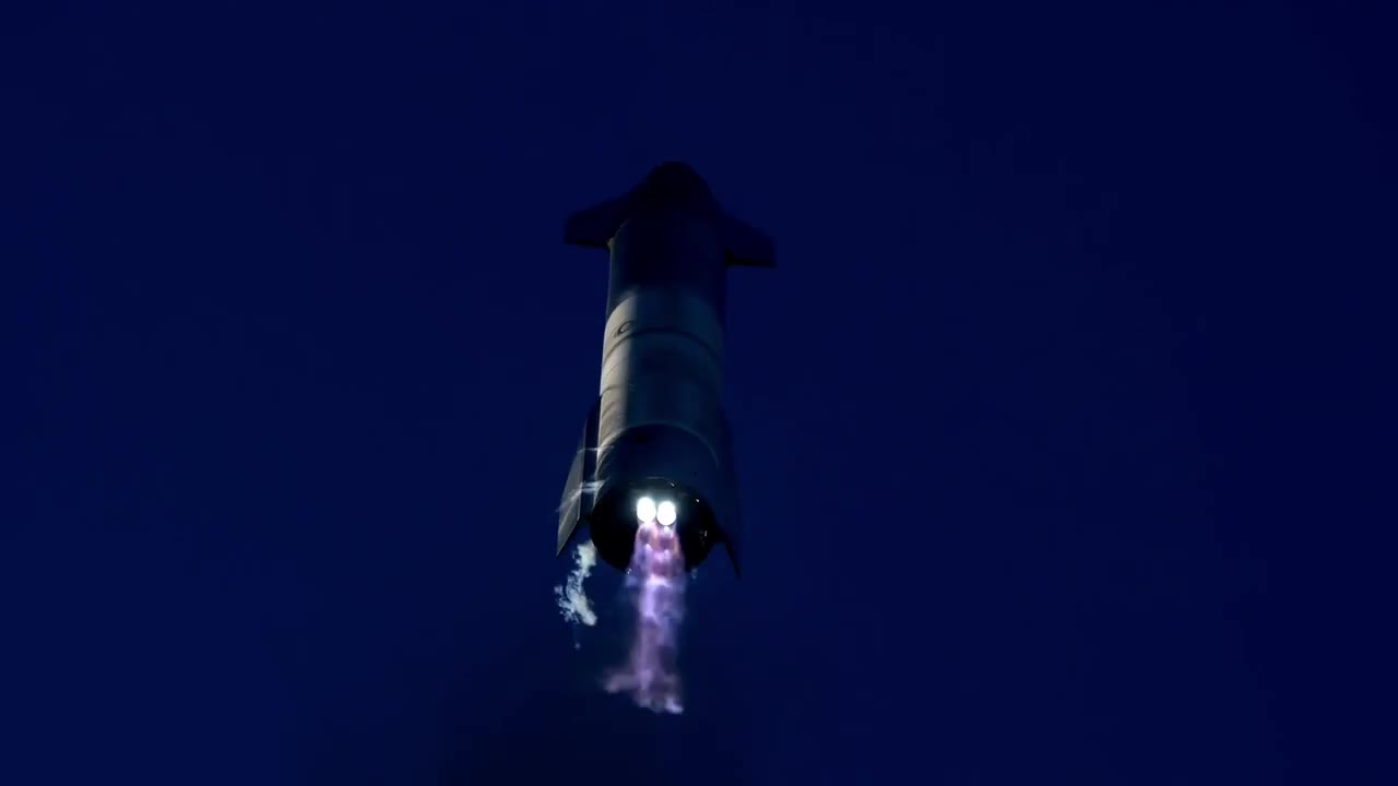 Starship SN8 flipping upright with two Raptor engines glowing against a dark sky