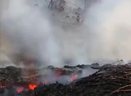 Lava glowing under a cloud of ash.