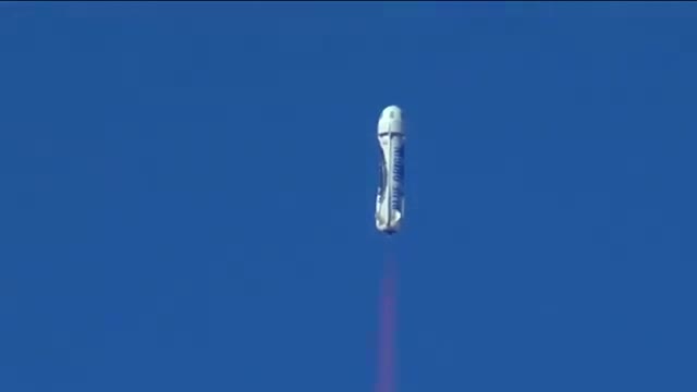 A New Shepard booster climbing under its own flame.
