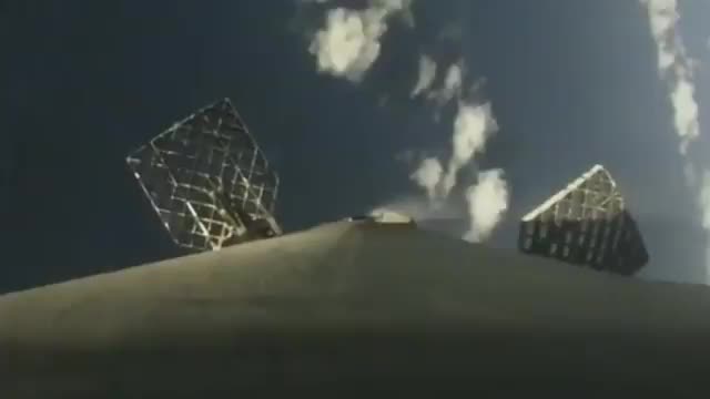 Grid fins on a rocket against the sky.