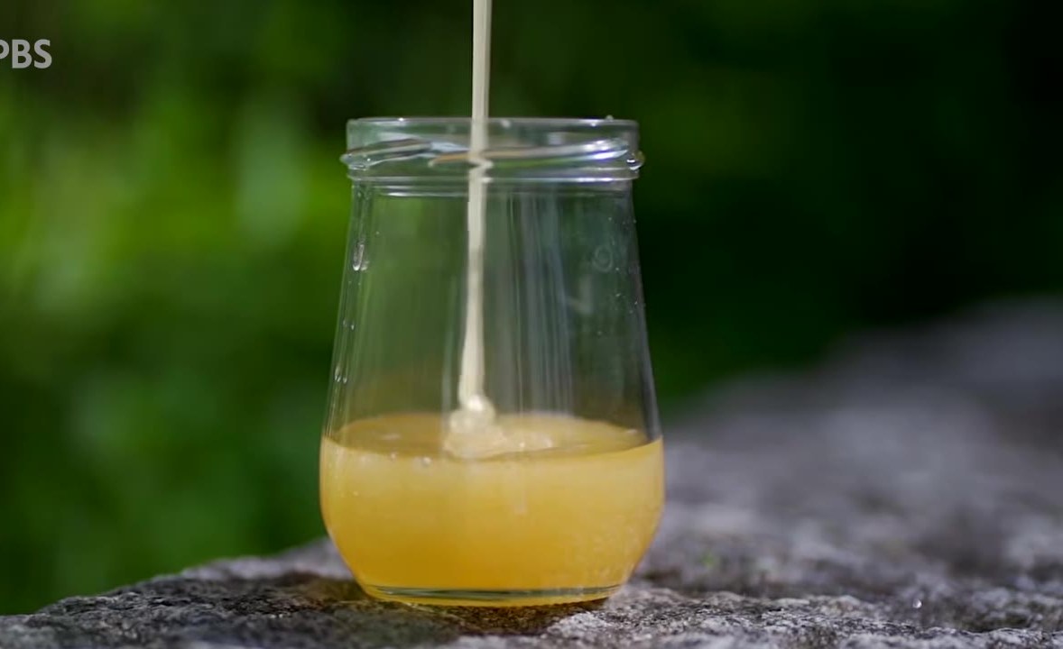 Stream of liquid pouring into a clear jar