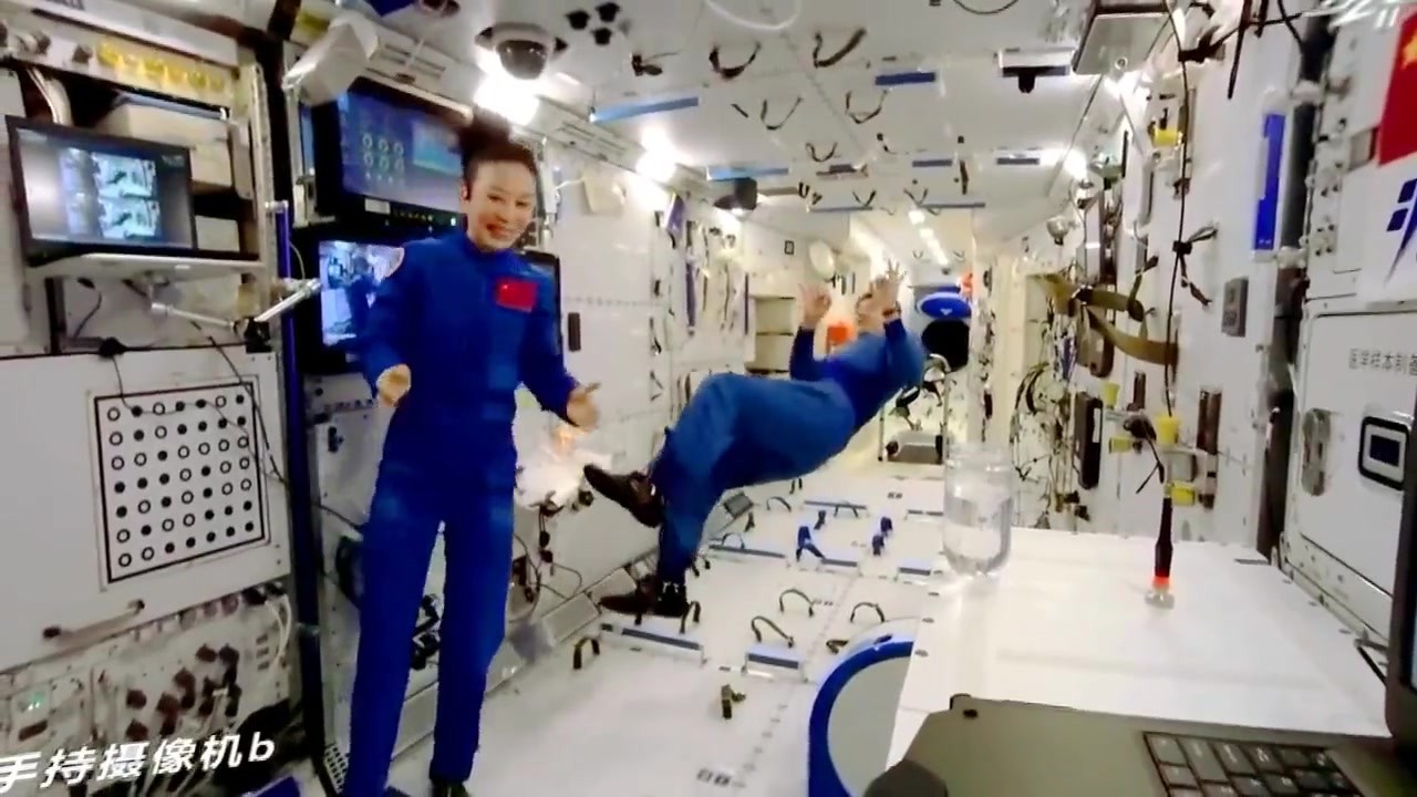 Chinese taikonaut floating in Tiangong demonstrating conservation of angular momentum