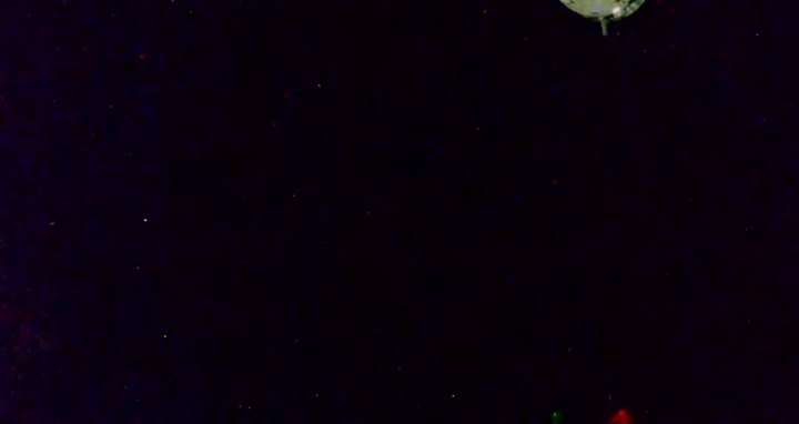 Crew Dragon pulling away from the station against a black sky