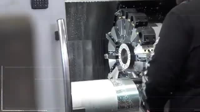 A machining center cutting a large cylindrical metal rocket part