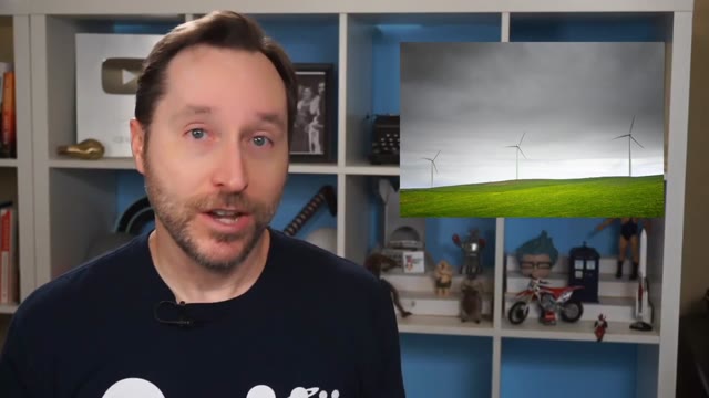 Engineer explaining flow batteries beside a wind-farm poster