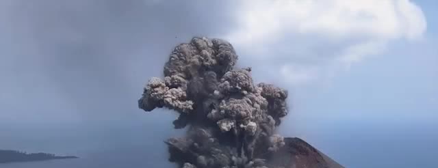 An ash plume rising from Anak Krakatau over the sea.