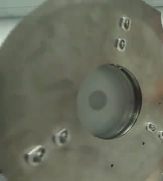 A round metal heat shield with a dark center.
