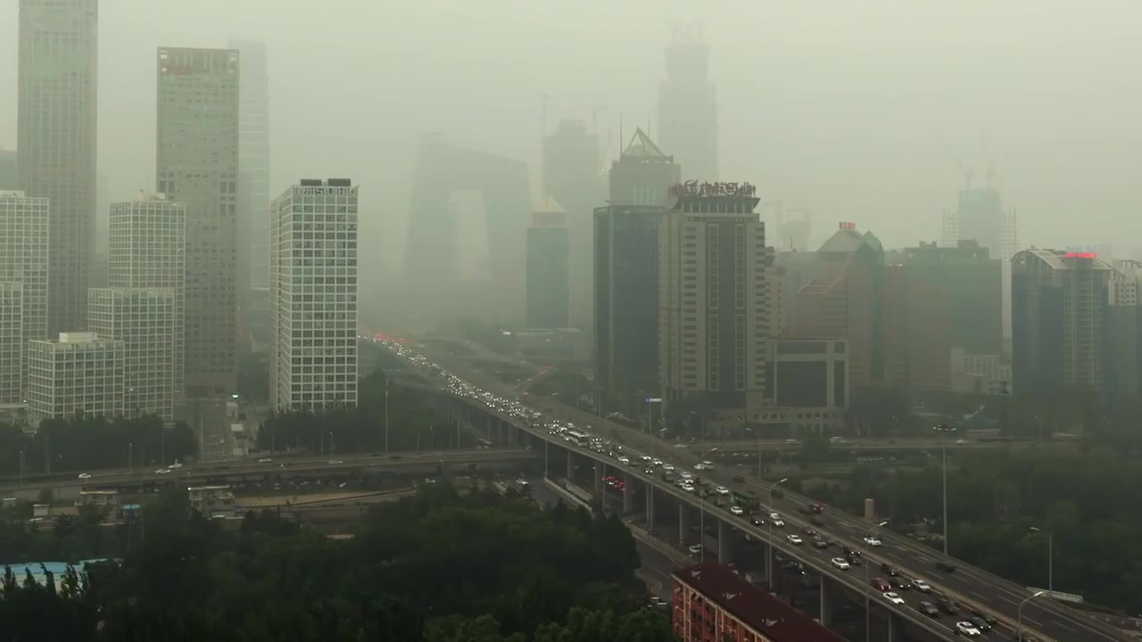 Smog-filled city skyline with heavy traffic on an elevated highway