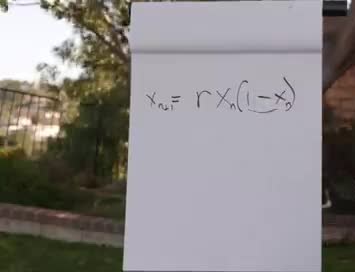 A notepad showing the logistic map equation x next equals r times x times one minus x.