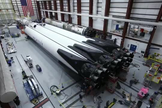 Three Falcon Heavy cores lying side by side inside the hangar