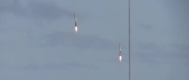 Two Falcon boosters descending engines-first, one above the other