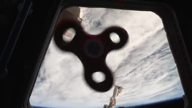A fidget spinner floating in front of Earth