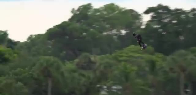 A flyboard high over a tree line