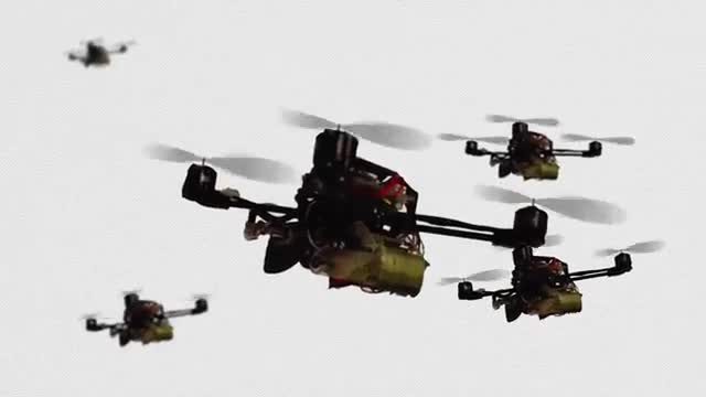 Several small FlyCroTug drones carrying yellow payloads