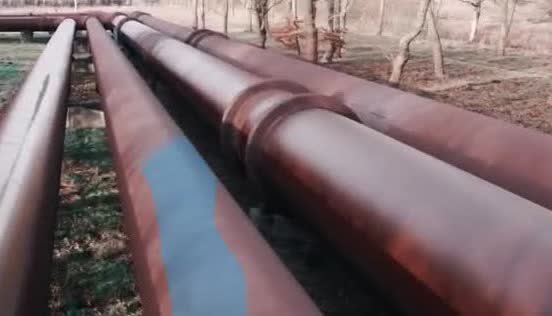 Large pipes running side by side through a field