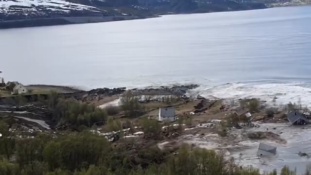 Houses and debris at the edge of a fjord after a landslide