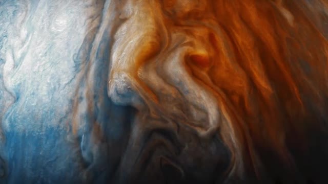 Swirling orange, white, and blue cloud bands on Jupiter