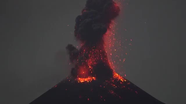 Red lava and sparks around a dark ash plume.