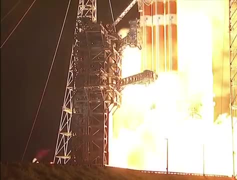 A rocket lifting off in a bright plume at night.