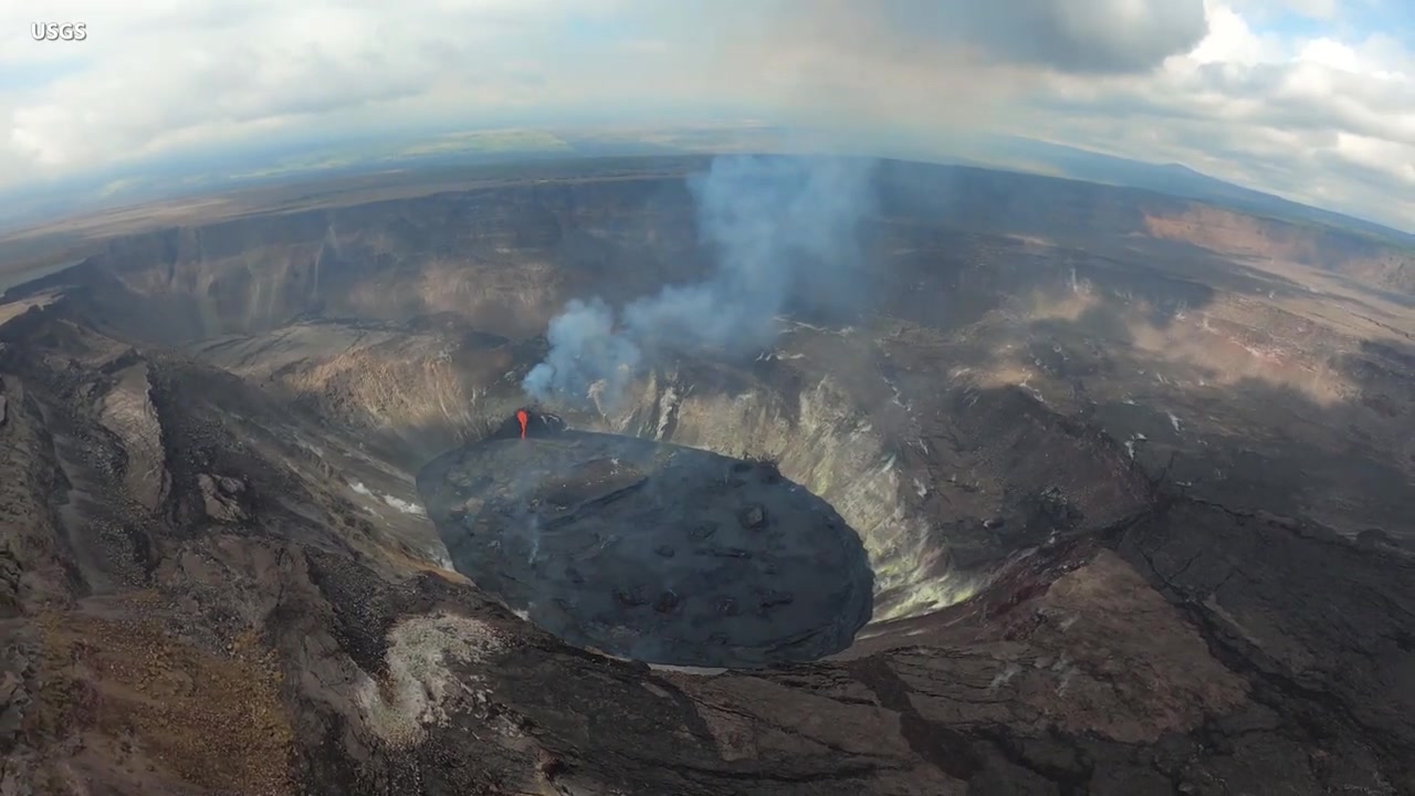 Aerial view of Halemaumau crater with a glowing vent and steam plume