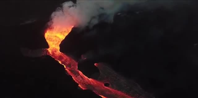 A river of lava flowing through dark rock.