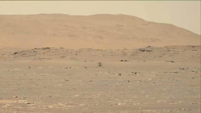 A small helicopter flying above the Martian surface.