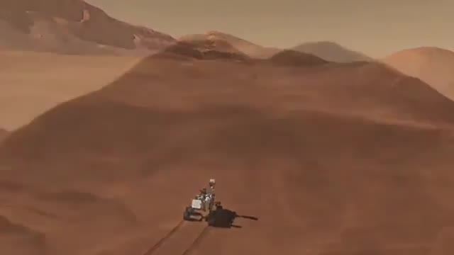 The Curiosity rover on rusty Martian ground with hills behind it