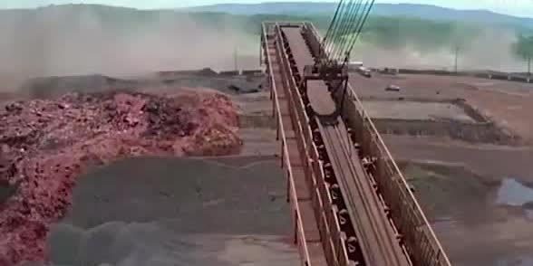 Mud from a collapsed mine tailings dam beside a conveyor