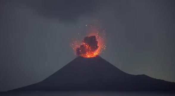 Anak Krakatau erupting at night over the water.
