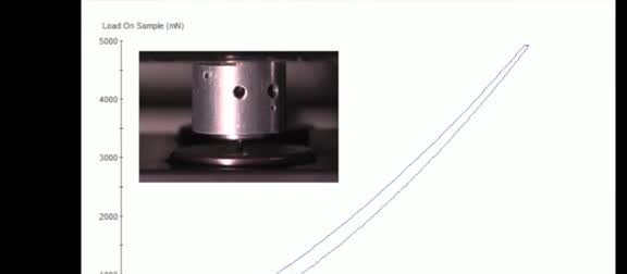 A load-displacement curve beside a metal sample holder