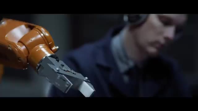 An orange robot arm in the foreground.