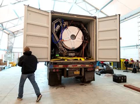 Rocket hardware sitting inside an open shipping container in a hangar