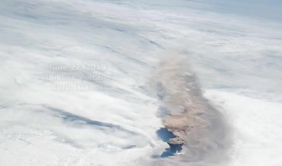 A volcanic plume rising from a small island, seen from orbit
