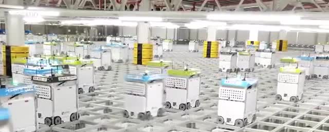 Warehouse robots moving across a grid floor.