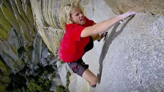 A climber on a sheer granite wall with no rope.