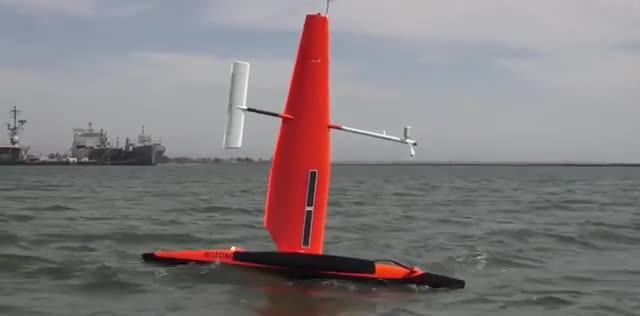 An orange unmanned sailboat on the bay