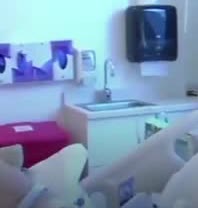 A hospital room with a sink and dispensers