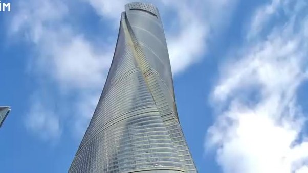 Twisting glass skyscraper rising into a cloudy sky