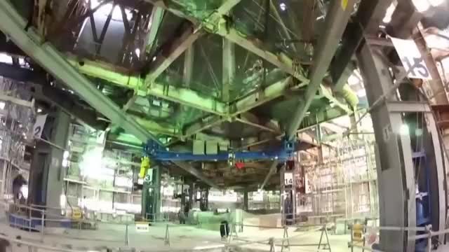 Interior of a building held on jacks, with the floor structure exposed and numbered columns around the edges.