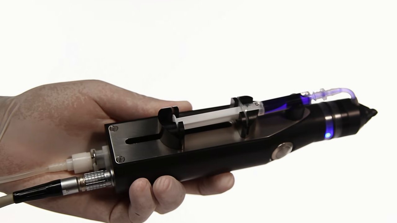 A hand holding the SkinGun, a handheld nozzle that sprays a patient’s own skin cells onto a burn.