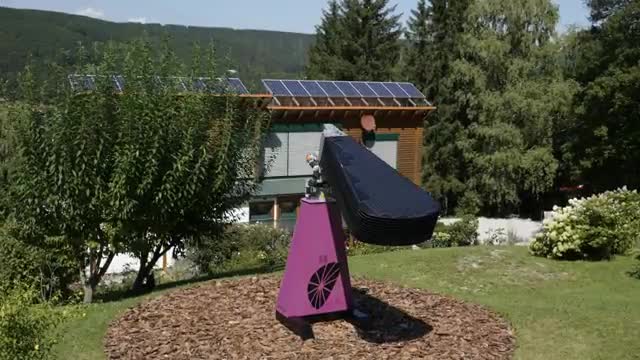 A solar array shaped like a flower opening in a garden.