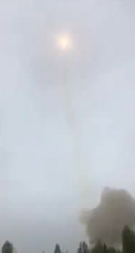 A Soyuz rocket climbing through cloud as lightning flashes nearby