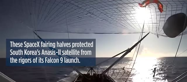 Payload fairing half in a ship’s net on the ocean