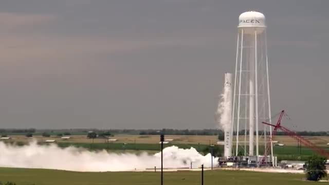 Rocket engine firing beside a water tower
