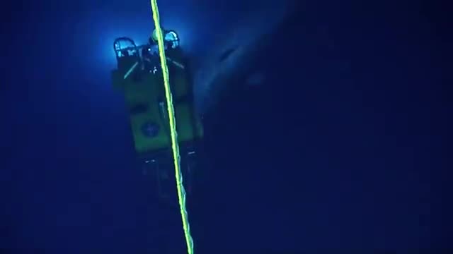 A whale beside a lit underwater vehicle