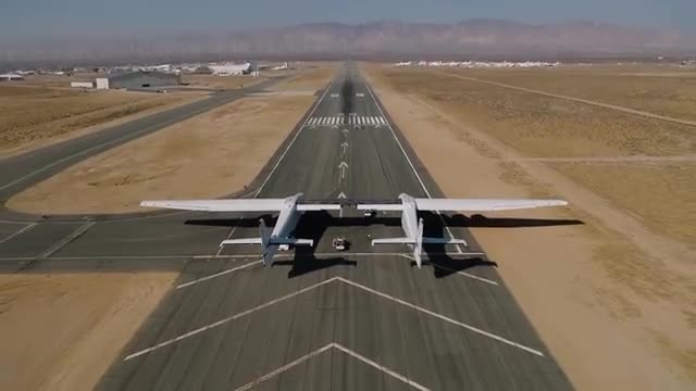 A twin-fuselage plane on a runway.