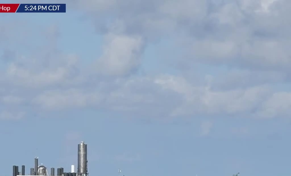 Boca Chica tank farm and Starship prototype under a bright sky
